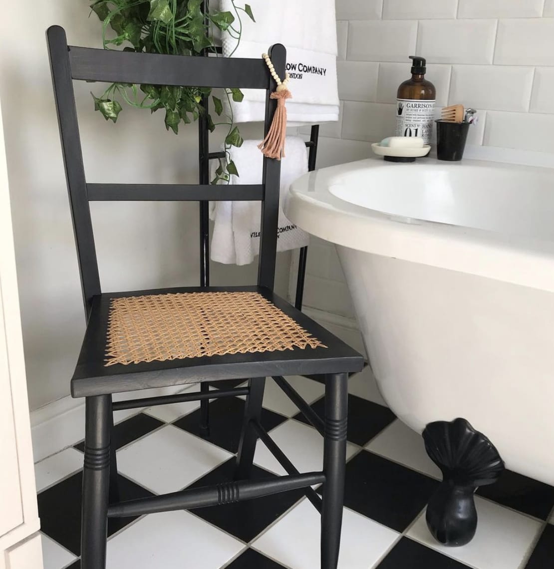 Черный стул с плетеным сиденьем в черно-белой ванной комнате
