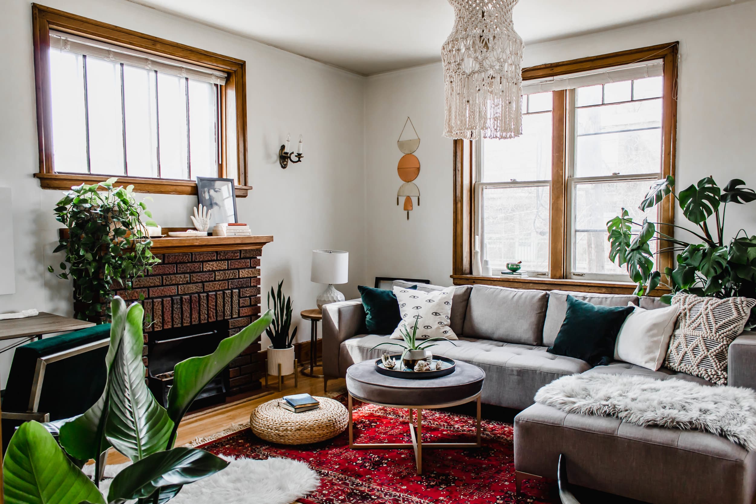 Декор гостиной с камином: абажур макраме, диванные подушки и растения