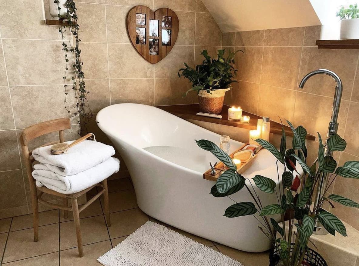 Деревянный стул и растения в бежевой ванной комнате