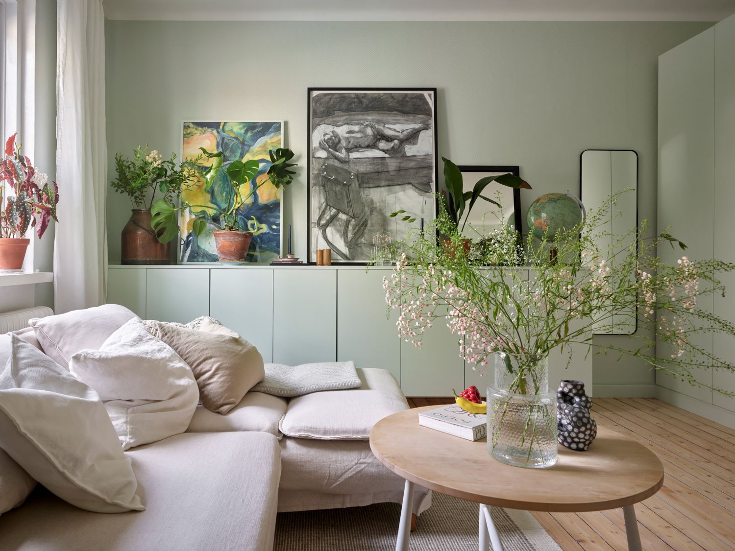 Картины, растения и зеркала в гостиной